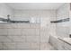 Bright bathroom with elegant white tile, shower fixture, and window to provide natural light at 7524 Pineridge Trl, Castle Pines, CO 80108