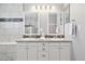 Bright bathroom with double vanity, granite counters, tile backsplash, and modern fixtures at 7524 Pineridge Trl, Castle Pines, CO 80108