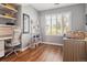 A cozy bedroom with a desk, comfortable daybed, and bright natural light from the large window at 7524 Pineridge Trl, Castle Pines, CO 80108