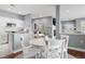 A sunlit dining area features a white round table and chairs, adjacent to an open-concept kitchen and living area at 7524 Pineridge Trl, Castle Pines, CO 80108