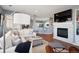 Spacious living room featuring an open layout, fireplace, TV and seamless flow to the kitchen and dining area at 7524 Pineridge Trl, Castle Pines, CO 80108