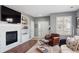 Inviting living room featuring a fireplace, built-in shelving, and a cozy reading chair at 7524 Pineridge Trl, Castle Pines, CO 80108