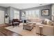 Bright living room with plantation shutters and neutral tones featuring a comfortable sectional sofa with accent seating at 7524 Pineridge Trl, Castle Pines, CO 80108