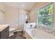 Elegant bathroom featuring a soaking tub with marble surround and a large window, plus a modern vanity at 2552 E 126Th Way, Thornton, CO 80241