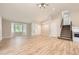 Open-concept living room featuring light floors, high ceilings, a bay window, and a staircase to the upper level at 2552 E 126Th Way, Thornton, CO 80241