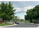 Peaceful street view with mature trees, a glimpse of a lake and lush landscaping, creating a serene neighborhood setting at 2552 E 126Th Way, Thornton, CO 80241