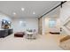 Finished basement with TV, sectional sofa, barn door, and a small window at 9437 E 51St Dr, Denver, CO 80238