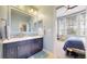 Stylish bathroom with a double sink vanity and view into a bedroom with guitars and windows at 9437 E 51St Dr, Denver, CO 80238