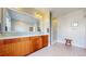 Modern bathroom with a double vanity, tiled floor, and glass-enclosed shower at 9437 E 51St Dr, Denver, CO 80238