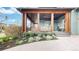 Inviting front porch with wooden columns, cozy seating, and lush landscaping, creating a welcoming entrance at 9437 E 51St Dr, Denver, CO 80238