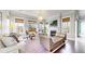 Bright living room featuring a fireplace, stylish furniture, large windows, and hardwood floors at 9437 E 51St Dr, Denver, CO 80238