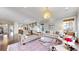 Bright living room with modern chandelier, stylish furniture, and views into kitchen at 9437 E 51St Dr, Denver, CO 80238