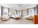 Spacious main bedroom boasts a tray ceiling, four-poster bed, seating area, and soft neutral tones at 9437 E 51St Dr, Denver, CO 80238