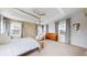 Inviting main bedroom with tray ceilings, a seating area, neutral tones, and plenty of natural light at 9437 E 51St Dr, Denver, CO 80238