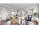 Bright home office with multiple windows, hardwood floors, and comfortable seating area at 9437 E 51St Dr, Denver, CO 80238