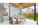 Cozy outdoor dining area on patio with wooden pergola and comfortable seating at 9437 E 51St Dr, Denver, CO 80238