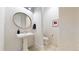 Chic powder room with patterned wallpaper, pedestal sink, and modern fixtures at 9437 E 51St Dr, Denver, CO 80238
