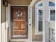 Elegant wood front door with glass inserts, decorative wreath, and modern doorbell at 9938 Grove Way # B, Westminster, CO 80031