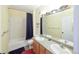 Well-lit bathroom features double sinks, large mirror, and tub with shower at 8481 W Union Ave # 2-201, Littleton, CO 80123