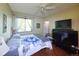 Bedroom featuring hardwood floors, a bed, a window with see-through curtains, and 2 TVs on top of each other at 8481 W Union Ave # 2-201, Littleton, CO 80123