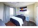 Bedroom with a window, hardwood floors, and featuring a ceiling fan, blue end tables, and a Colorado flag hanging on the wall at 8481 W Union Ave # 2-201, Littleton, CO 80123