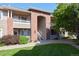 Brick and siding condo building with green lawn and manicured landscaping. Balconies and stairs provide entryways at 8481 W Union Ave # 2-201, Littleton, CO 80123