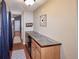 Hallway featuring tile-topped wooden cabinets, hardwood floors, and leading to a white door at the end of the hall at 8481 W Union Ave # 2-201, Littleton, CO 80123