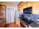 Efficient kitchen with stainless steel appliances, wood cabinets, and easy-to-clean surfaces for functional cooking at 8481 W Union Ave # 2-201, Littleton, CO 80123