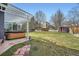 Landscaped backyard with a hot tub on a patio, spacious lawn, and mature trees for serene outdoor living at 16442 Bluebonnet Dr, Parker, CO 80134