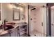 Industrial bathroom with modern vanity, vessel sink, and walk-in shower featuring pebble floor at 16442 Bluebonnet Dr, Parker, CO 80134
