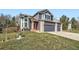 Charming two-story home featuring a red door, three-car garage, and well-maintained lawn at 16442 Bluebonnet Dr, Parker, CO 80134