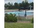 Community pool area with a splash pad, lounge chairs, shaded seating and mature trees in the background at 16442 Bluebonnet Dr, Parker, CO 80134