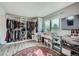 Spacious walk-in closet with shelves, hanging racks, vanity and a vibrant pink patterned rug at 16442 Bluebonnet Dr, Parker, CO 80134