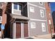 Multi-story condo building with gray siding, brick accents, and clearly marked unit entrances at 14353 E 1St Dr # 201, Aurora, CO 80011