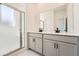 Bathroom featuring double sinks, a large mirror, and tiled shower with glass doors at 27742 E 1St Ave, Aurora, CO 80018