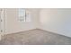 Neutral bedroom with a window, grey carpet, and white walls at 27742 E 1St Ave, Aurora, CO 80018