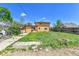 Backyard view of property with yellow siding, a shed, and grass at 6671 Grove St, Denver, CO 80221