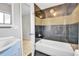 Cozy bathroom featuring stylish black and gold tiled walls and a bathtub at 6671 Grove St, Denver, CO 80221