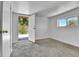 Bedroom with white walls, neutral carpet, and exterior access door and window at 6671 Grove St, Denver, CO 80221