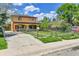 Two-story home with a fenced front yard, long driveway, and mature landscaping at 6671 Grove St, Denver, CO 80221