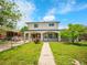 Inviting two-story home with a covered porch, walkway, and beautiful front yard landscaping at 6671 Grove St, Denver, CO 80221
