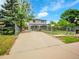 Traditional two-story home featuring a spacious driveway and a well-manicured front yard at 6671 Grove St, Denver, CO 80221