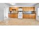 Spacious kitchen with wood cabinets, laminate countertop, white appliances and tiled backsplash at 6671 Grove St, Denver, CO 80221