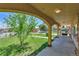 Covered front porch with classic archways offering a view of the landscaped yard at 6671 Grove St, Denver, CO 80221