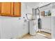 Utility room with water heater, furnace, and upper cabinets, showcasing essential home systems at 6671 Grove St, Denver, CO 80221
