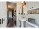 Hallway bathroom featuring sink, toilet, mirror and storage shelf at 2562 N Emerson St, Denver, CO 80205