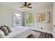 Light bedroom with a ceiling fan, hardwood flooring, rug, and two windows at 2562 N Emerson St, Denver, CO 80205