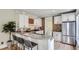 Bright kitchen featuring white cabinets, brick accent wall, stainless steel refrigerator, granite counters and bar seating at 2562 N Emerson St, Denver, CO 80205