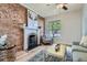 Stylish living room featuring exposed brick, a white fireplace, and a plush rug for cozy charm at 2562 N Emerson St, Denver, CO 80205