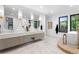 Bright bathroom featuring double vanity, stand alone tub, large windows, and modern fixtures at 1126 S Garfield St, Denver, CO 80210